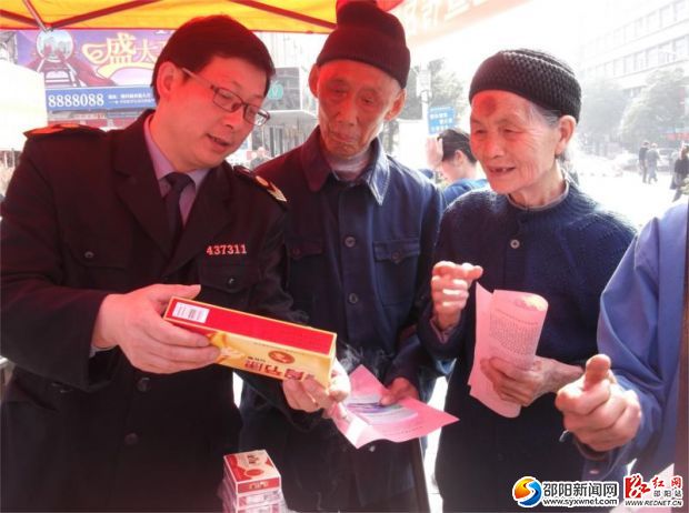 圖為隆回縣食品藥品監(jiān)督管理局工作人員向過往群眾介紹辨別假劣食品藥品的方法