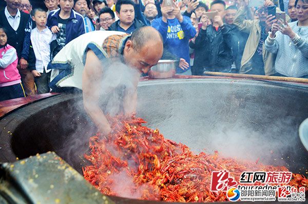 “鬼谷神功”大師唐程剛將手伸進(jìn)油鍋，翻炒龍蝦。