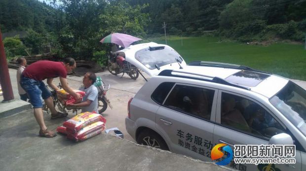 圖為：裝米上車為受災群眾運送到戶的現(xiàn)場