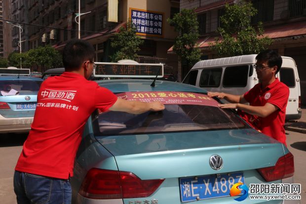 工作人員為愛心送考出租車張貼標(biāo)識(shí)