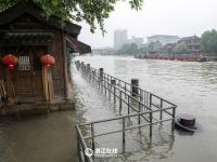 京杭大运河水位上涨 杭州市民下水捞鱼