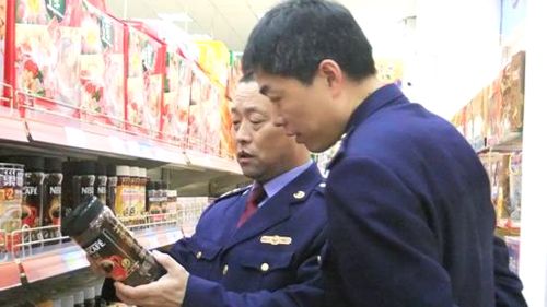 图为工商执法人员在超市检查食品。