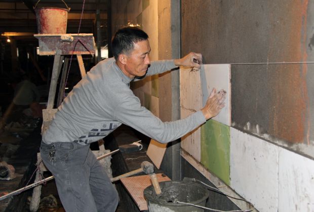 施工人员正在给农贸市场内墙镶瓷板砖