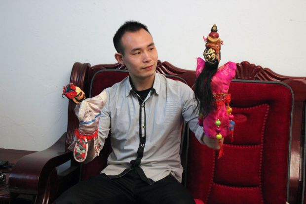 刘强在进行邵阳布袋戏表演和展示