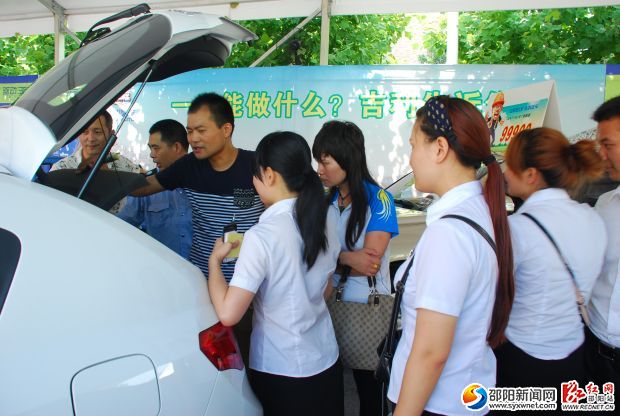 市民在车展上向销售人员了解汽车性能。