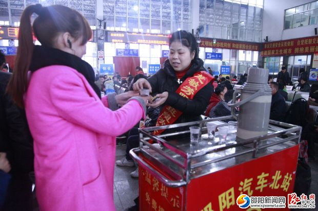 学雷锋（龙敏芳特色）服务班组正在为旅客送上开水。