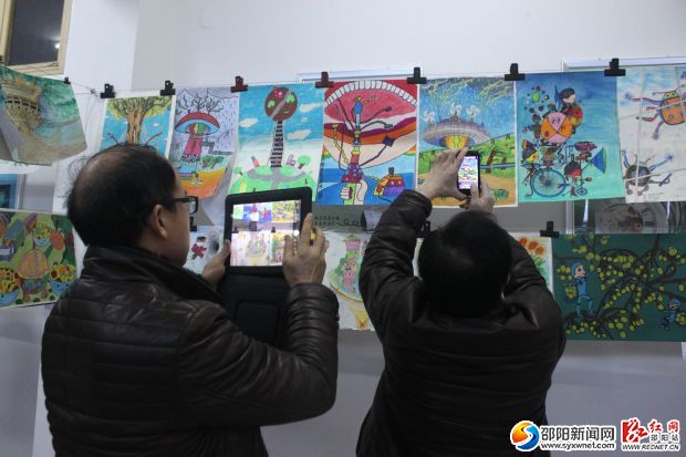评委纷纷用电子设备将心目中优异的作品拍摄下来。