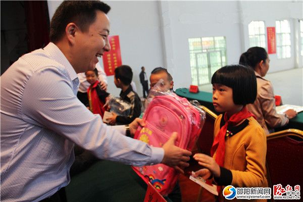 5、电力公司书记吴毅在给小朋友发捐赠物品