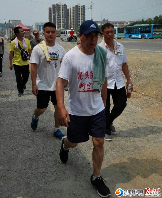 在酷热的320国道上,林承雄从怀化出发,向着家乡新宁坚毅前行。