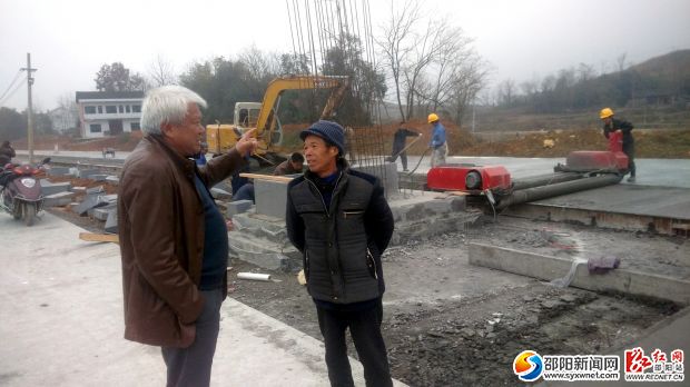 陈立新（左）来到连接洞新高速与高沙的高沙大道施工现场