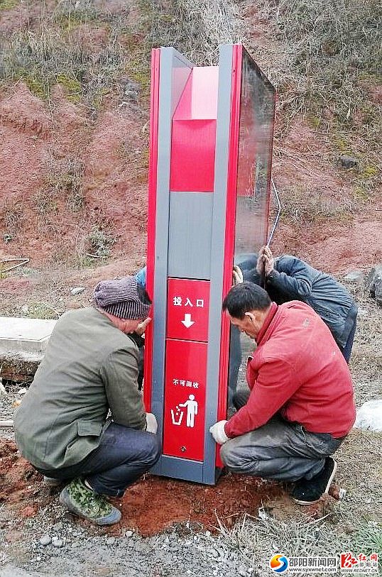 (图为施工人员正在峎山大道安装阳能多功能保洁箱)