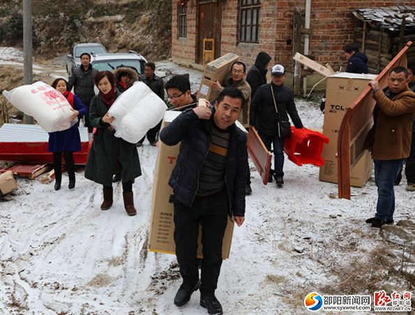 图为段书记一行在山道上搬运物品
