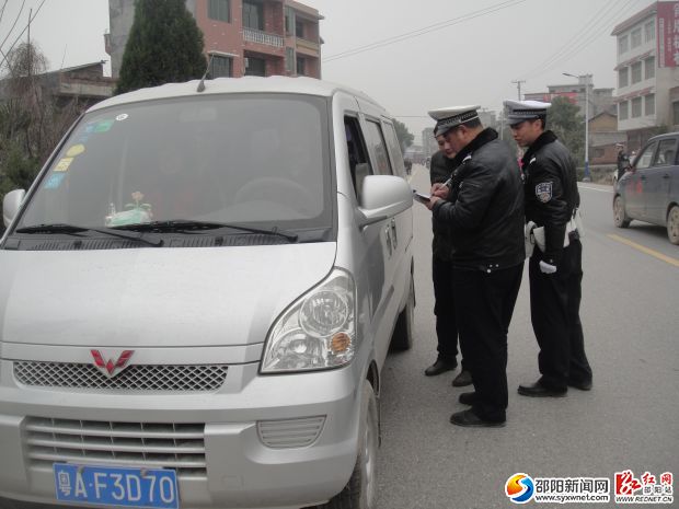 交警正在荷香桥镇查处面包车超载情况
