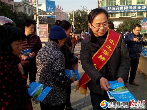 图为隆回县水土保持局工作人员上街发放宣传资料