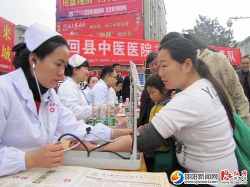 隆回中医医院志愿者在为群众测量血压。