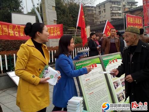隆回县合管办志愿者在县城街头发放《农村合作医疗服务手册》等宣传资料。
