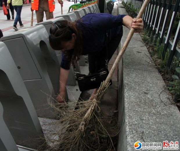 扫帚扫不到的地方何春雄就用手把垃圾抠出来（资料图）。