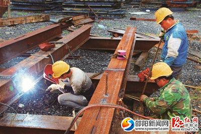 雪峰大桥施工现场,工人们正在切割钢条。