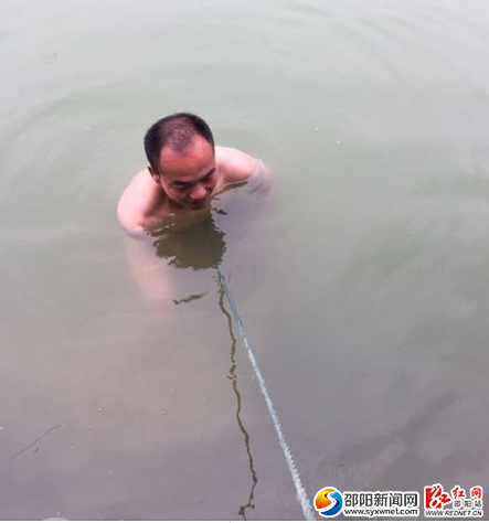 图二:村主任下塘去拉泄洪栓,绳子底下是出现的裂缝
