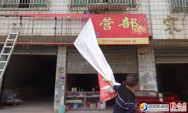 工作人员正在拆除门店招牌