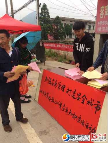 图为工作人员正在发放宣传资料