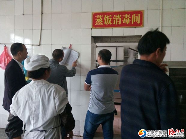 图为联合执法队对学校食堂进行安全检查