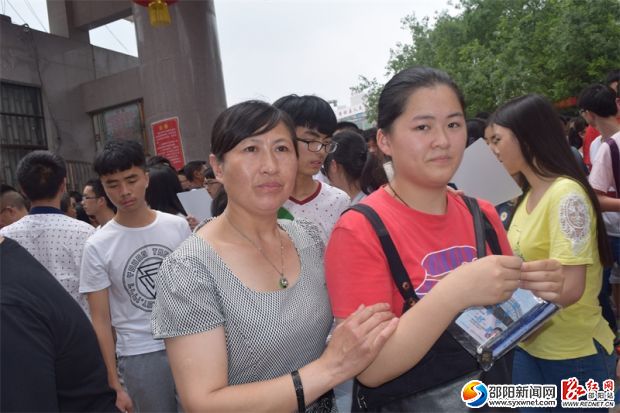 一女生在家长的陪伴下走出考场