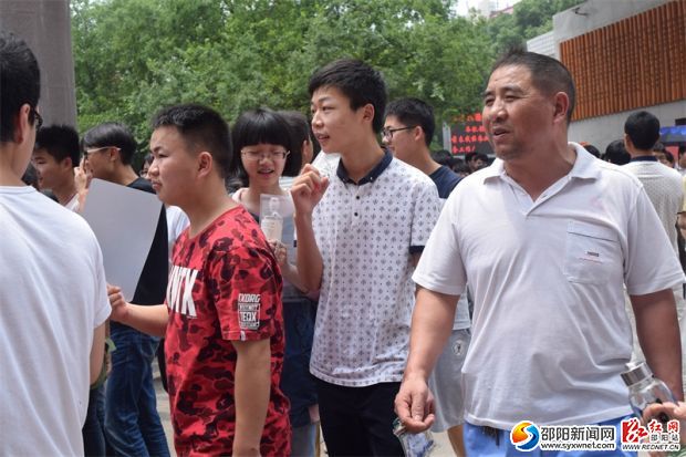 考生们陆续走出考场,一家长在焦急张望等待自己的孩子