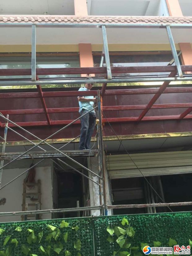 工作人员依法拆除违章户外广告