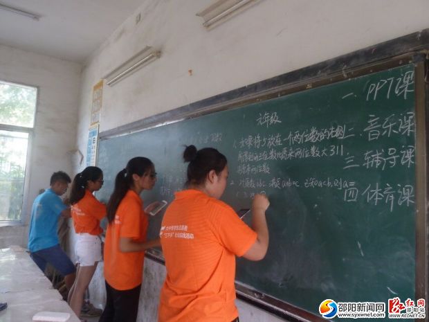 (志愿者们在黑板上给孩子们出题目)