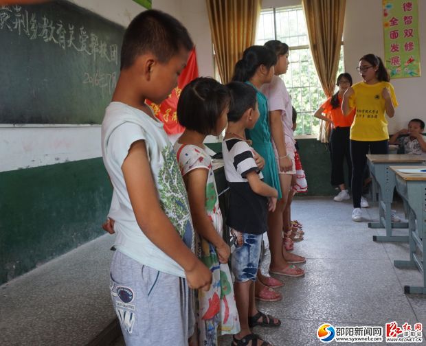 图为志愿者与小朋友玩游戏