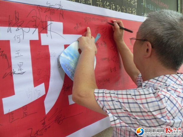 （市民们纷纷在横幅上签下自己的名字）