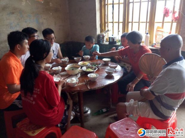 (志愿者与吴霞、杨照贵两位老人一起吃饭)