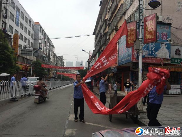 图为执法人员正在清除跨街横幅
