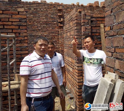 镇长蒋凯兵(右一)和镇人大主席伍建文检查危房改造