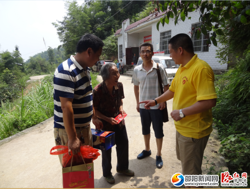 图为老百姓商贸张总为林江村特困户送去爱心资金