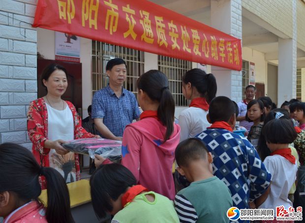 工作人员正在为学生发放爱心书包、文具