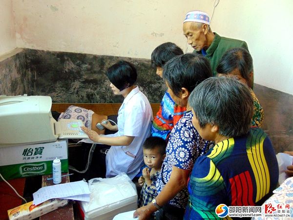 图为少数民族老幼群众在接受免费B超检查