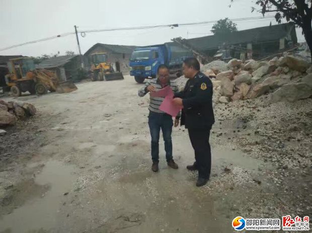 图为执法人员为相关从业人员解说治超新规