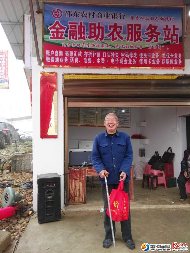 图为何业梅在服务站领取低保款