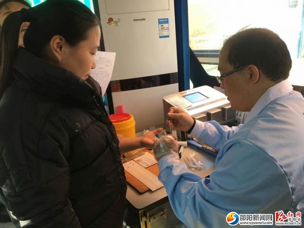 图为医护人员为献血者采血