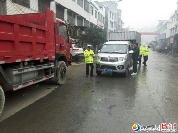 图为工作人员对过往车辆进行检查