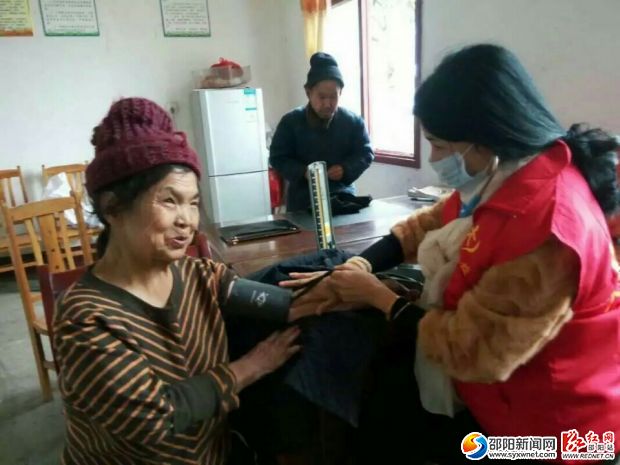 图为志愿者医生为老人检查身体