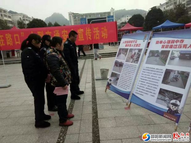 图为过往行人在了解交通法规看板资料
