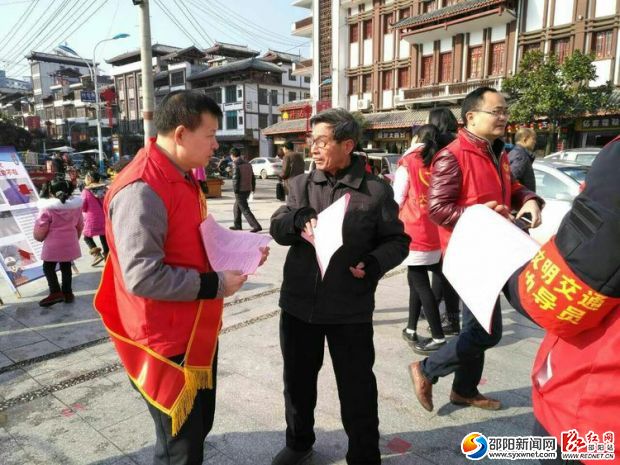 图为志愿者在和路人讲解交通安全知识