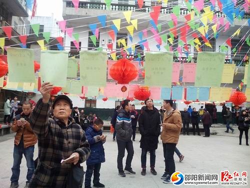 老年市民在仔细反复察看谜面。