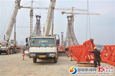 2月9日，施工人员正在桂花大桥桥头安装龙门吊，为铺设桥板做准备。