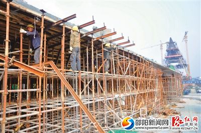 2月9日，市区雪峰大桥施工现场，工作人员正在拆除引桥模板