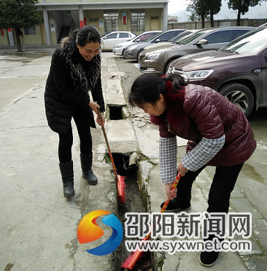 贺小红、黄镁老师正在清除学校阴沟