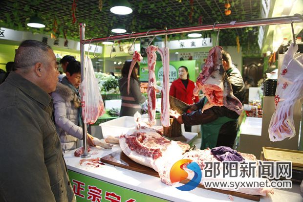 市民正在仔细询问摊位上的宁乡花猪肉与普通猪肉有什么区别。